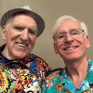 Two smiling older men wearing colorful patterned shirts